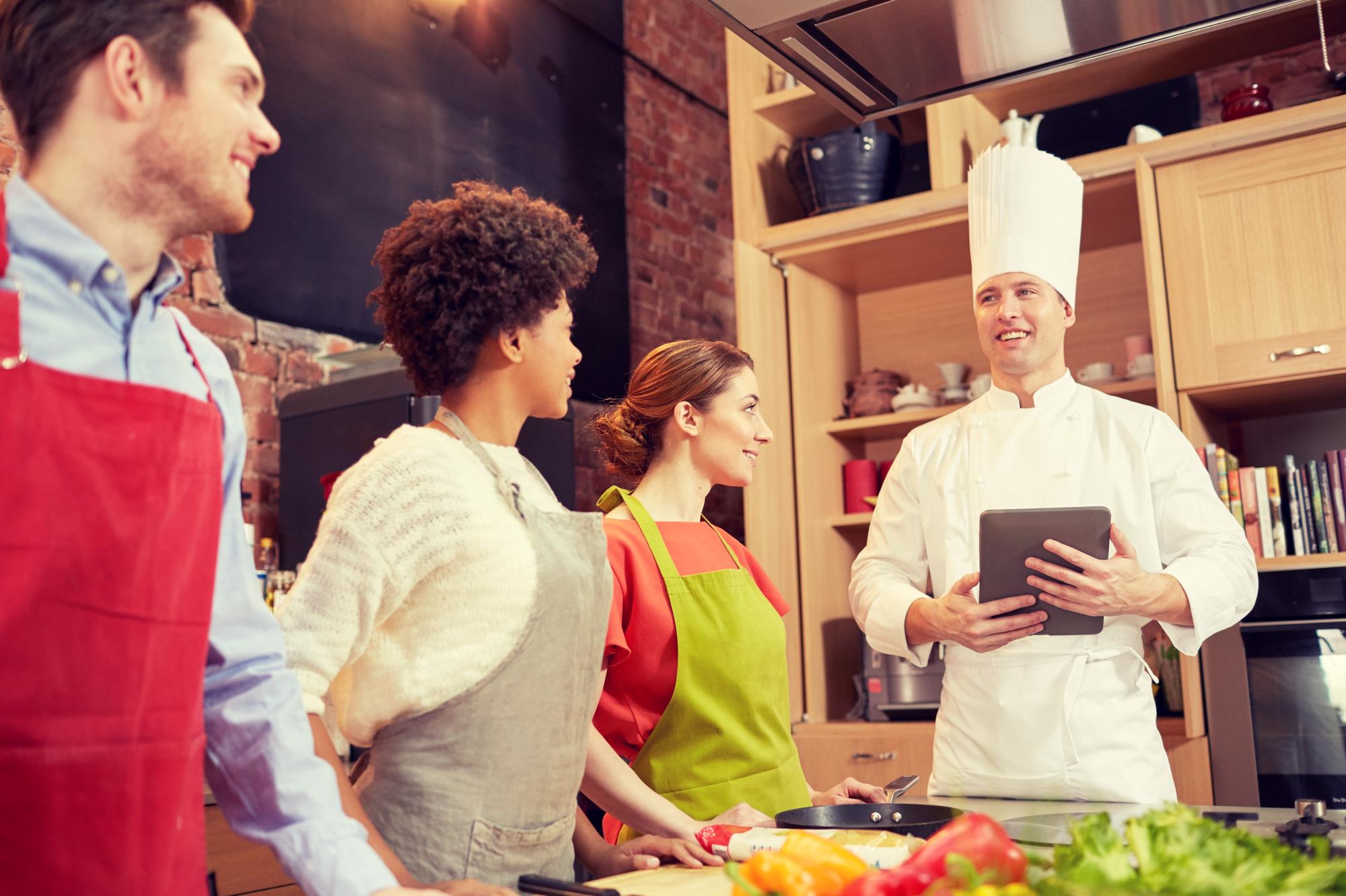 Chef talking with small group in warm kitchen